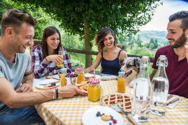 Fröhliche Gruppe von Freunden beim Frühstück in einem Bauernhaus - Junge Leute essen im Garten, Konzepte über gesunde Lebensweise und Ernährung - DMDF05717