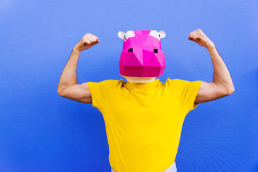 Cool man wearing 3d origami mask with stylish colored clothes - Creative concept for advertising, animal head mask doing funny things on colorful background - DMDF05754