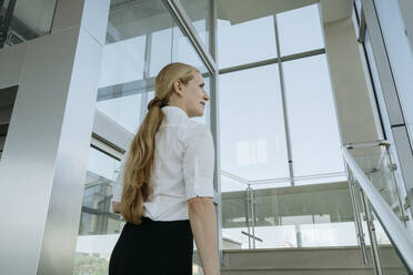 Geschäftsfrau, die auf einer Treppe im Büro geht - OSF02163