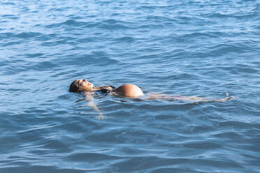 Pregnant woman floating on sea water - PCLF00711