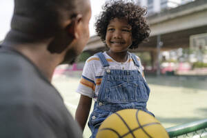 Glücklicher Sohn im Gespräch mit seinem Vater auf dem Basketballplatz - IKF01257