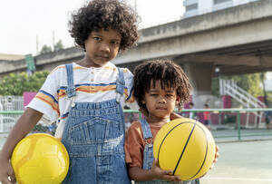 Jungen halten Basketbälle auf dem Sportplatz - IKF01258