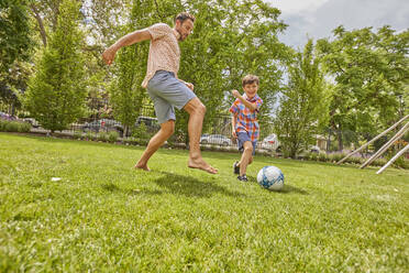 Vater und Sohn (8-9) spielen Fußball im Park - TETF02237