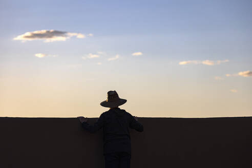 Silhouette of man in hat looking at sunset - TETF02251