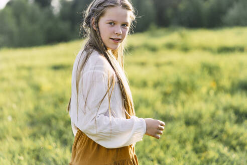Happy girl standing in meadow - VBUF00390