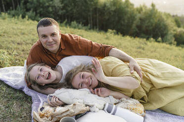 Glückliche Familie, die Spaß hat und auf einer Decke auf einer Wiese liegt - VBUF00394