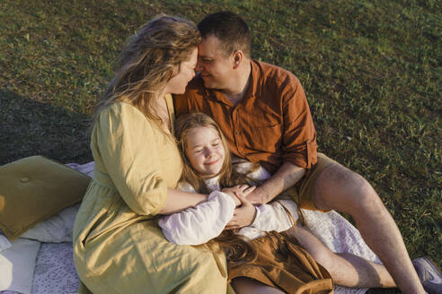 Loving parents with daughter spending leisure time on grass - VBUF00403