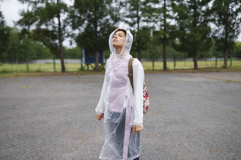 Portrait of young woman standing with closed eyes in rain - TETF02299