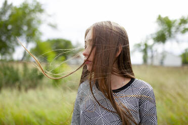 Blonde young woman with tousled hair in field - TETF02312