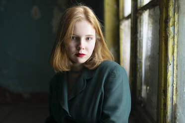 Portrait of teenage girl (16-17) wearing red lipstick and looking at camera - TETF02326