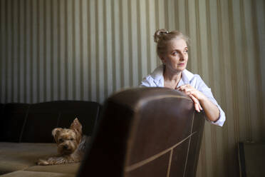 Frau auf dem Sofa sitzend mit Yorkshire-Terrier zu Hause - TETF02334