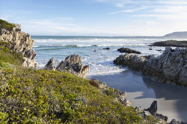 South Africa, Hermanus, Rocky coastline with Atlantic Ocean in Voelklip Beach on sunny day - TETF02363