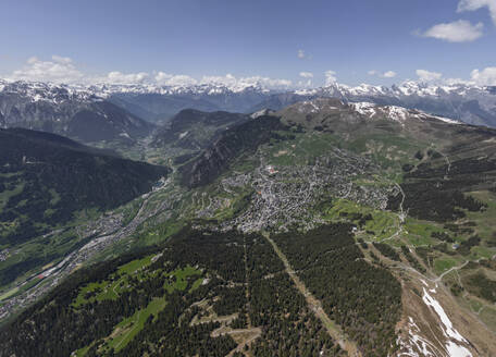 Malerischer Blick auf eine Bergkette mit schroffen, schneebedeckten Gipfeln und grünem Gras an einem sonnigen Frühlingstag in den Alpen - ADSF47923