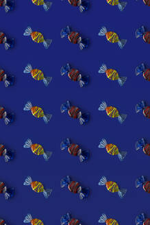 Draufsicht auf ein Muster aus ganzen süßen Kristallbonbons, die auf blauem Hintergrund angeordnet sind - ADSF47944