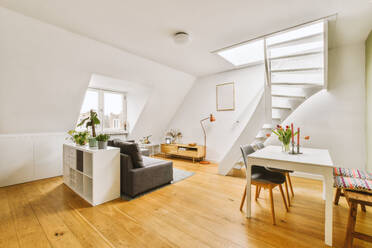 Interior of spacious living room with stairs leading to upper floor and furniture placed of hardwood floor in contemporary apartment - ADSF47958