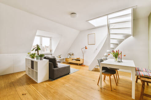 Innenraum eines geräumigen Wohnzimmers mit Treppe zum Obergeschoss und Möbeln aus Hartholzboden in einer modernen Wohnung - ADSF47958