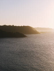 Sea near mountains under sky at sunset - MMPF00946