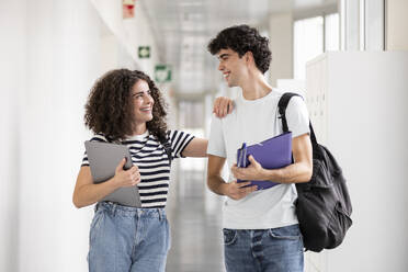 Smiling students talking in corridor - LMCF00609