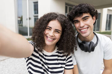 Fröhliche Studenten machen ein Selfie vor dem Gebäude und genießen ihre Studienzeit - LMCF00643