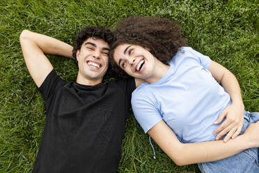 Young friends relaxing and laughing on grass - LMCF00666