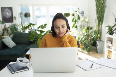 Geschäftsfrau arbeitet an einem Laptop am Schreibtisch im Heimbüro - VRAF00206
