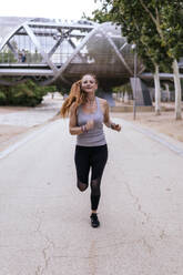 Entschlossene Frau joggt auf dem Fußweg im Park - PBTF00312