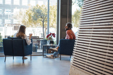 Geschäftskollegen sitzen auf Stühlen in der Büro-Lobby - JOSEF21046