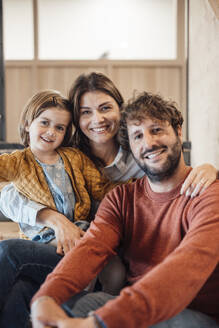 Vater und Mutter sitzen mit ihrer Tochter im Büro - JOSEF21058