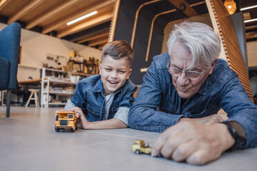 Großvater und Enkel spielen zu Hause mit Spielzeugautos - JOSEF21108