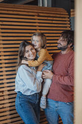 Happy family enjoying together near wooden wall at home - JOSEF21118