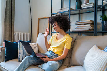 Porträt einer attraktiven jungen Latina in ihrem Zuhause mit lockigen Haaren und Einblick in ihren Lebensstil und Alltag - DMDF05789