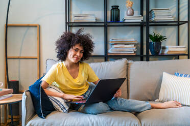 Beautiful latino young woman at home - Pretty south american with curly hair female portrait, lifestyle and domestic life scene - DMDF05793