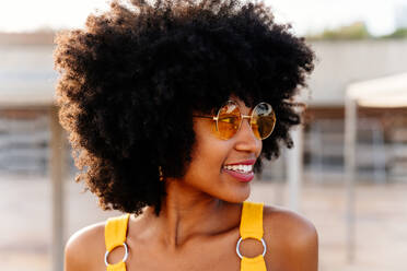 Beautiful young happy african woman with afro curly hairstyle strolling in the city - Cheerful black student portrait outdoors - DMDF06006