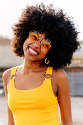 Beautiful young happy african woman with afro curly hairstyle strolling in the city - Cheerful black student portrait outdoors - DMDF06010