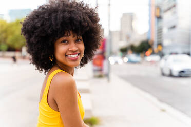 Beautiful young happy african woman with afro curly hairstyle strolling in the city - Cheerful black student girl walking on the street - DMDF06033