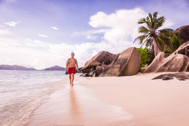 Tourist an einem schönen Strand mit weißem Sand auf einer tropischen Insel der Seychellen - der berühmte Strand Anse d'Argent auf La Digue - DMDF06094