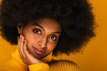 Porträt einer attraktiven Afroamerikanerin bei einer Beauty-Session im Studio - Schöne Frau posiert vor farbenfrohem Hintergrund - DMDF06098