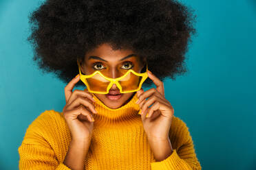 Porträt einer attraktiven Afroamerikanerin bei einer Schönheitsbehandlung im Studio - Schöne Frau posiert vor farbenfrohem Hintergrund - DMDF06102