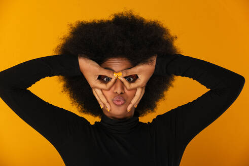 Porträt einer attraktiven Afroamerikanerin bei einer Beauty-Session im Studio - Schöne Frau posiert vor farbenfrohem Hintergrund - DMDF06118