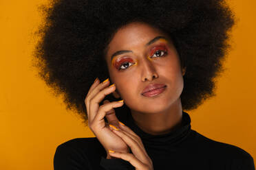 Porträt einer attraktiven Afroamerikanerin bei einer Schönheitsbehandlung im Studio - Schöne Pose vor farbenfrohem Hintergrund - DMDF06119