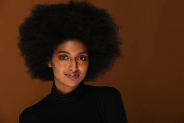 Porträt einer attraktiven Afroamerikanerin bei einer Beauty-Session im Studio - das schöne Model posiert vor farbenfrohem Hintergrund - DMDF06120