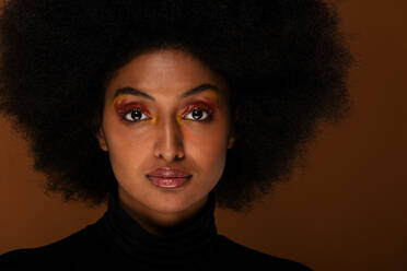 Porträt einer attraktiven Afroamerikanerin bei einer Beauty-Session im Studio - Schöne Frau posiert vor farbenfrohem Hintergrund - DMDF06125