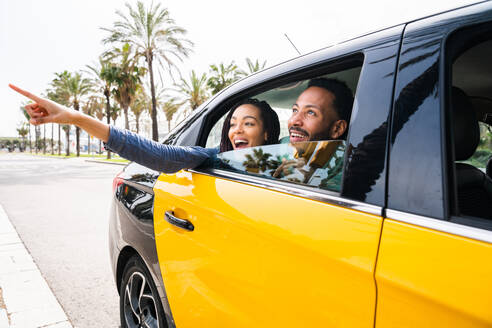 Schönes glückliches hispanisches lateinisches Liebespaar, das sich im Freien verabredet - Touristen in Barcelona, die während der Sommerferien Spaß haben und in einem Taxi fahren - DMDF06387