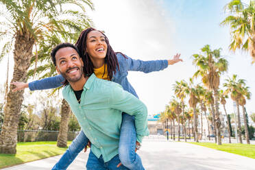 Beautiful happy hispanic latino couple of lovers dating outdoors - Touristen in Barcelona haben Spaß während des Sommerurlaubs, Menschen, die in einem Park mit tropischen Palmen - DMDF06390