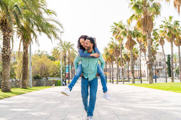 Beautiful happy hispanic latino couple of lovers dating outdoors - Touristen in Barcelona haben Spaß während des Sommerurlaubs, Menschen, die in einem Park mit tropischen Palmen - DMDF06391