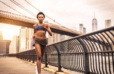 Young fitness woman running in New York - Sportive girl training outdoors, concepts about sport and healthy lifestyle - DMDF06440