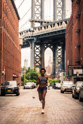 Young fitness woman running in New York - Sportive girl training outdoors, concepts about sport and healthy lifestyle - DMDF06443