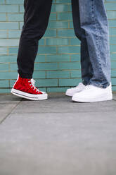 Man and woman standing on footpath near wall - AMWF01717