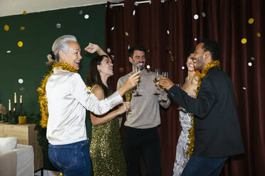Happy men and women with drinking glasses dancing at new year party - EBSF03833