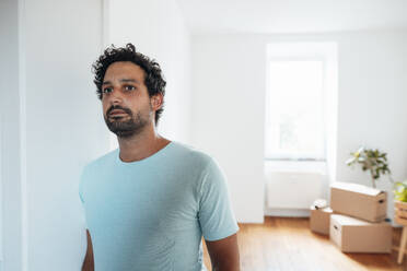 Thoughtful man standing near wall at home - JOSEF21147